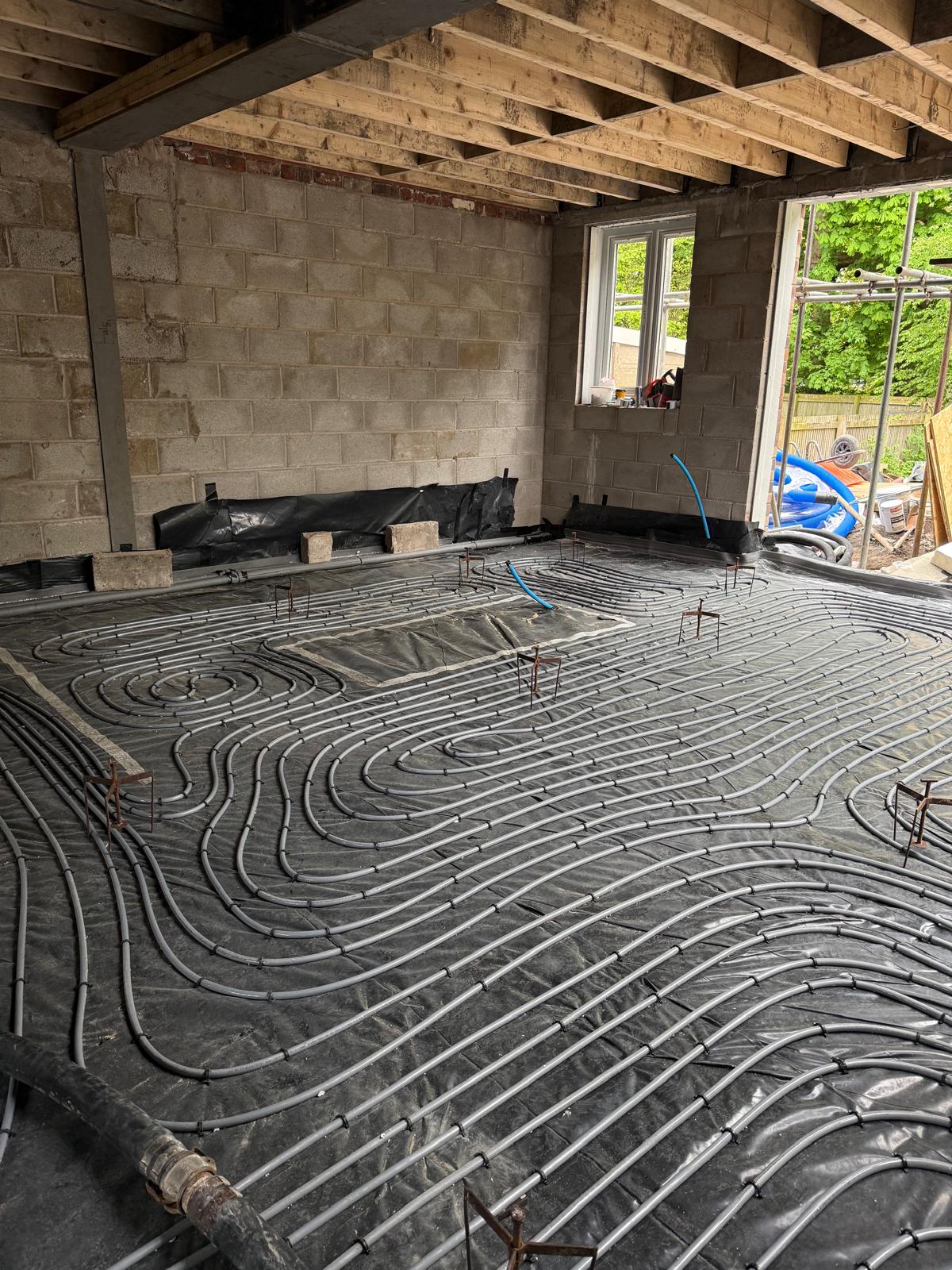 New-build UFH pipework laid in continuous serpentine pattern over DPM and insulation in a ground-floor extension, ready for screed