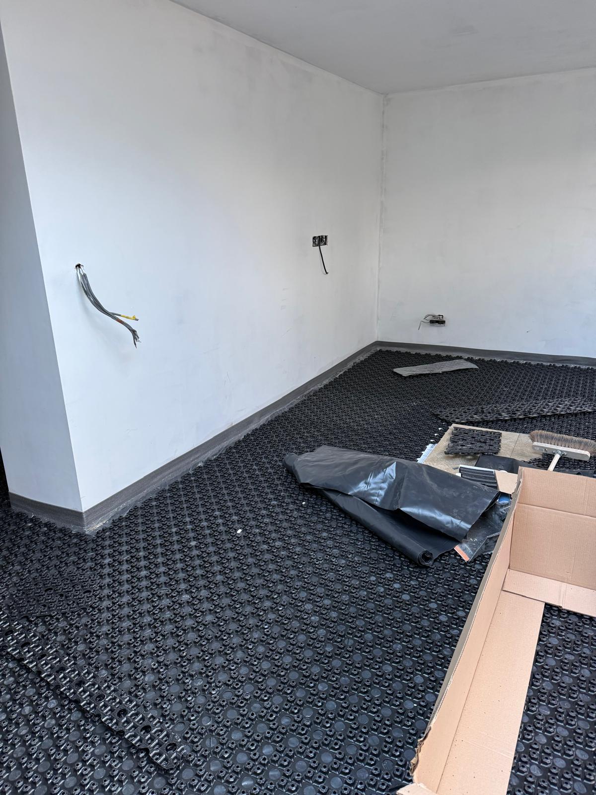 Low-profile overlay UFH panels positioned over an existing floor